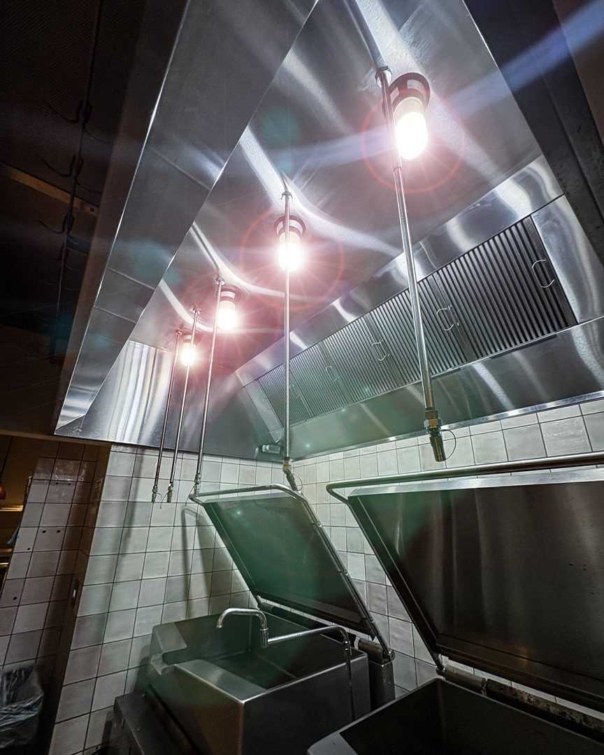 Commercial kitchen ventilation hood system with fire suppression nozzles and stainless steel equipment